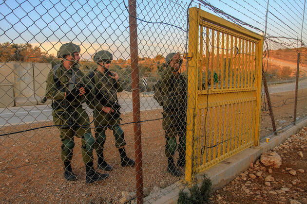 November 2, 2022, Salfit, Palestine: An Israeli soldier opens the gate of the separation barrier in the northern occupied West Bank for Palestinian farmers to enter their lands confiscated by Israel. Palestinian farmers closed the gates located on the wall separating the city of Salfit and the Jewish settlement of Ariel to reach their confiscated lands to pick olives, after the Israeli army opened them at seven in the morning and closed them until four in the evening and reopened them for the farmers to leave. Salfit Palestine - ZUMAs197 20221102_zaa_s197_140 Copyright: xNasserxIshtayehx