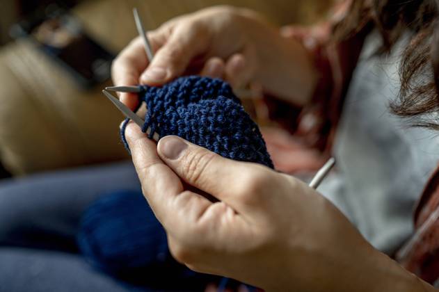 Woman knitting with blue wool at home model released, Symbolfoto, ANAF00099