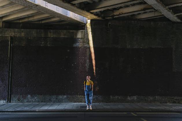Young androgynous person waiting on sidewalk below bridge model released, Symbolfoto, ASGF03010