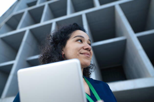 IMAGO Creative: Business, Innovative Technologie-Lösungen Smiling businesswoman with tablet PC in front of building model released, Symbolfoto, JOSEF13370
