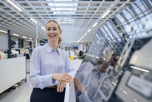 IMAGO Creative: Business, Innovative Technologie-Lösungen Happy businesswoman standing by desktop computer at industry model released, Symbolfoto property released, JOSEF14059