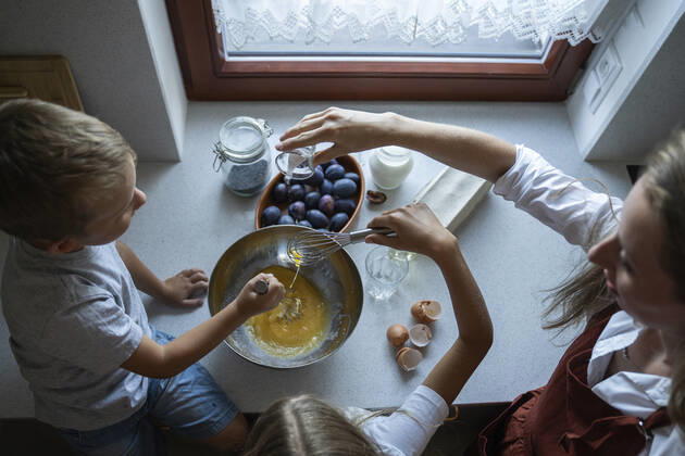 IMAGO Creative, Jahreszeit Sommer, Food, Pflaume Woman cooking cake of plums with children at home model released, Symbolfoto property released, NJAF00037