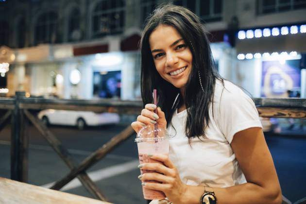IMAGO Creative, Jahreszeit Sommer, Sommer in der Stadt Happy beautiful woman with smoothie at sidewalk cafe model released, Symbolfoto, OYF00801