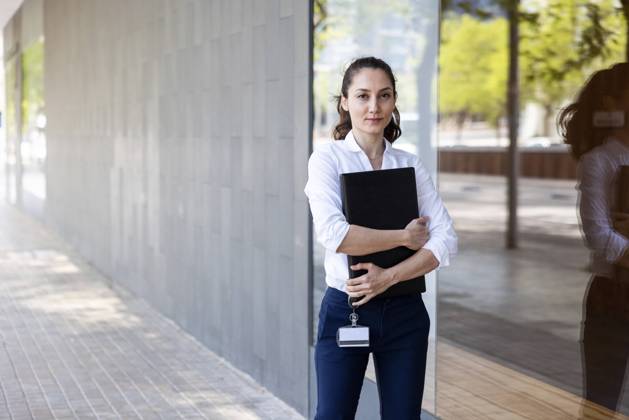 IMAGO Creative: Business, Innovative Technologie-Lösungen Businesswoman with laptop standing by glass at footpath model released, Symbolfoto, WPEF06595
