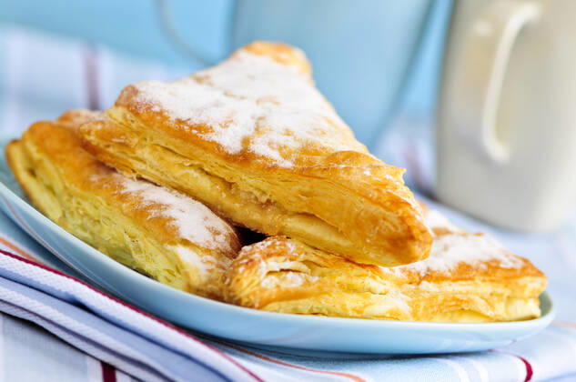 IMAGO Creative, Food, Gebäck, Apfeltaschen RECORD DATE NOT STATED Apple turnovers pastries with coffee cups in the background , 713645.jpg, pastry, pastries, apple, turnover, turnovers, fresh, bake, baked, bakery, food, dessert, desserts, plate, coffee, cup, cups, mug, mugs, freshness, sweet, sweets, treat, treats, baking, freshly, breakfast, lunch, snack, flaky, morning,