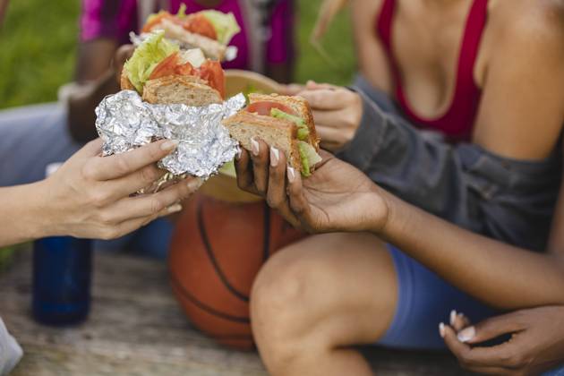 Women holding sandwich in park model released, Symbolfoto, JCCMF07924
