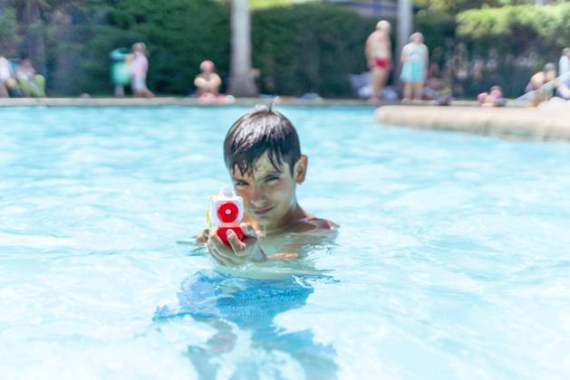 Dark-haired boy playing with the water gun in the pool Tarifa, Andalusia, Spain R_IGMA221216-1085974-01 ,model released, Symbolfoto