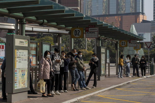 Daily Life In Macau Commuters wearing face masks while waiting for a bus at a bus stop on December 29, 2022 in Macau, China. Macau Macau  Copyright: xVernonxYuenx originalFilename: yuen-dailylif221229_npP7z
