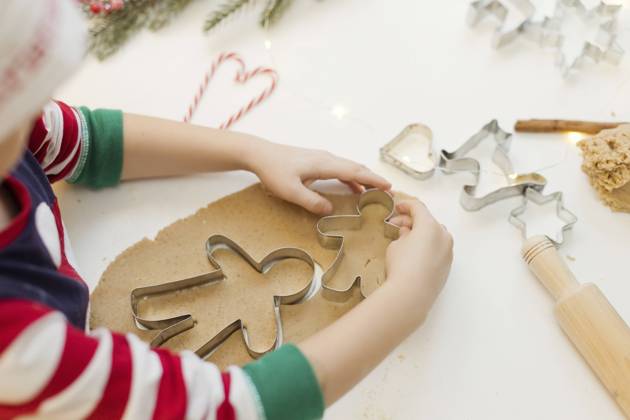 Hands of boy using cookie cutter on gingerbread dough in kitchen model released, Symbolfoto property released, ONAF00301