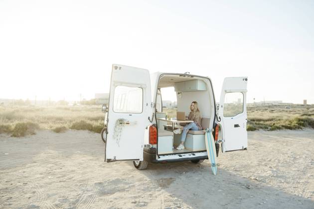 Young freelancer sitting with laptop in caravan in front of clear sky model released, Symbolfoto property released, RCPF01496