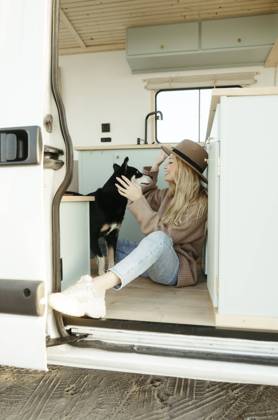 Young woman playing with dog inside motor home model released, Symbolfoto property released, RCPF01507