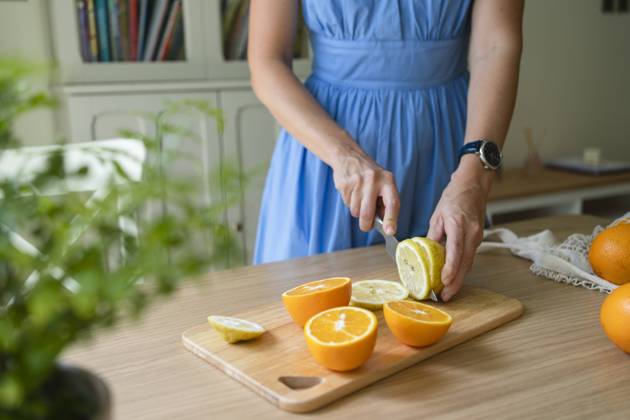 Hands of woman cutting lemons and oranges on table at home model released, Symbolfoto property released, SVKF00784