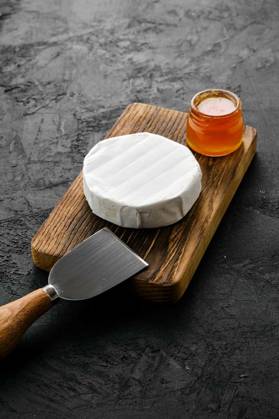  Piece of soft brie or camembert cheese, Piece of soft brie or camembert cheese on cutting board, Piece of soft brie or camembert cheese on cutting board, 20.09.2022, Copyright: xBoomeartx Panthermedia31874489.jpg