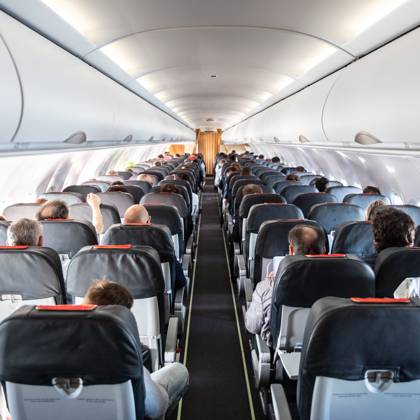Interior of commercial airplane with passengers on their seats during flight. Interior of commercial airplane with unrecognizable passengers on their seats during flight shot from the rear of airplane. Copyright: xZoonar.com MatejxKastelicx 12545655