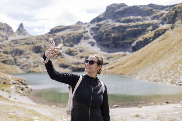 Smiling hiker taking selfie through mobile phone model released, Symbolfoto, MEF00148