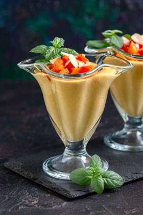 Dessert with peach slices and mint. Delicate dessert of milk, cream and fresh peaches in dessert glasses, served with slices of fresh mint and peach on a slate stand, selective focus. Copy space. Copyright: xZoonar.com MarinaxSaprunovax 18979113