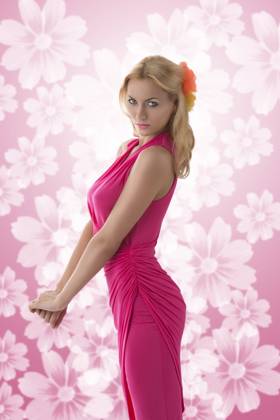 IMAGO Creative, Lifestyle, Barbiecore pretty blonde girl with pink dress and flowers in the hair, her body is in profile and she looks in to the lens Copyright: xcarloxdapinox xDesignxPicsx , 32084442  Copyright: IuliiaxSoshenkox xDesignxPics 32084442