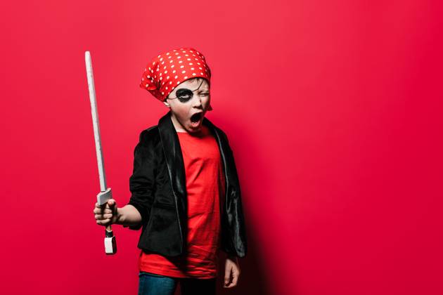IMAGO Creative, Gesellschaft, Fasching Cute boy in pirate outfit with sword screaming and looking at camera against bright red background, Model released HodeiUnzueta_ID12912_392224_006 Copyright: xHodeixUnzuetax MR