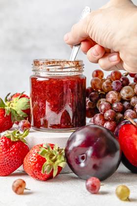 IMAGO Creative, Jahreszeit Sommer, Food, Marmelade kochen Hand of woman holding spoon with homemade strawberry jam on table model released, Symbolfoto, FLMF00932