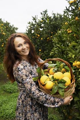 Happy redhead woman standing with basket of oranges model released, Symbolfoto, NJAF00212