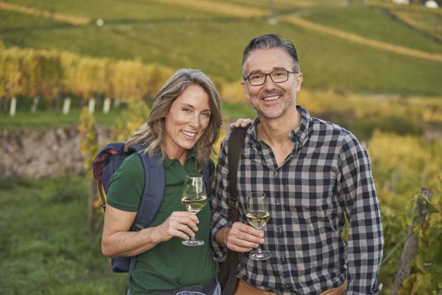 IMAGO Creative, Sommer, Weinfeste und Weinwanderungen Mature couple holding wineglasses on hill model released, Symbolfoto, RORF03377