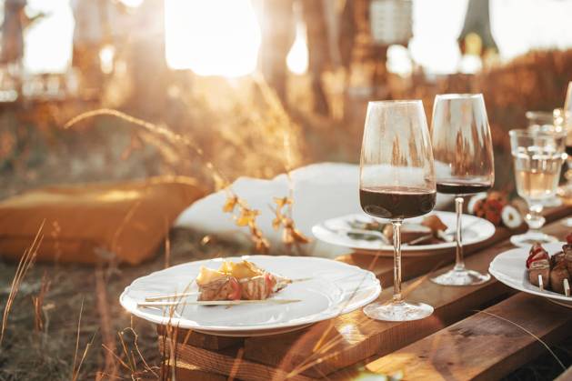 Wooden table with glassware arranged for picnic Set of elegant glassware placed on plank wooden table with floral arrangement on grassy meadow during festive autumn picnic Copyright: xZoonar.com DashaxPetrenkox 16822225 ,model released, Symbolfoto ,property released
