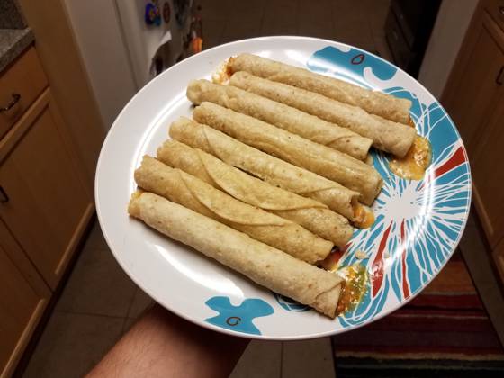 IMAGO Creative, Food, Taquitos RECORD DATE NOT STATED hand holding hot taquitos on plate in kitchen , 28044184.jpg, taquitos, texmex, food, hot, cheese, cheesy, plate, hand, holding, lunch, dinner, snack, junk food, kitchen, mexican, melted