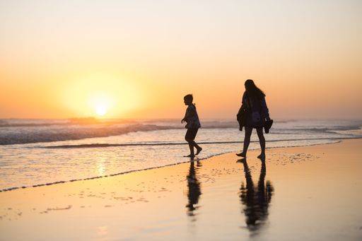 RECORD DATE NOT STATED A silhouette of a person walking down a sandy beach, illuminated by the soft light of a sunset over the ocean *** einer Schattenriss des einer person Spazierengehen nieder einer sandiger beach, beleuchtet indem der weich Licht des einer Sonnenuntergang trueber der Ozean 15030708 ,model released, Symbolfoto