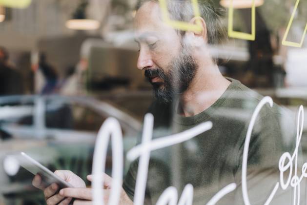 IMAGO Creative, Urban Lifestyle Mature man using tablet PC in cafe seen through glass model released, Symbolfoto property released, JOSEF17195