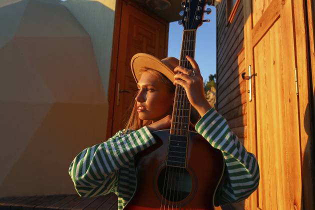 Creative Highlights Symbolbilder Thoughtful woman with guitar at sunset model released, Symbolfoto property released, SYEF00268