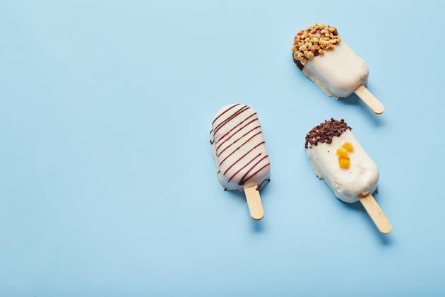 Mousse dessert with fruit flavors in the form of popsicle ice cream on blue background. Mousse dessert with fruit flavors in the form of popsicle ice cream covered with white chocolate on blue background. Copyright: xZoonar.com BurakovaxIrinax 18286087