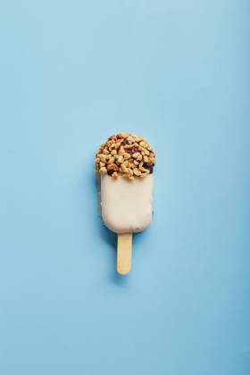 Mousse dessert with fruit flavors in the form of popsicle ice cream on blue background. Mousse dessert with fruit flavors in the form of popsicle ice cream covered with white chocolate on blue background. Copyright: xZoonar.com BurakovaxIrinax 18286092
