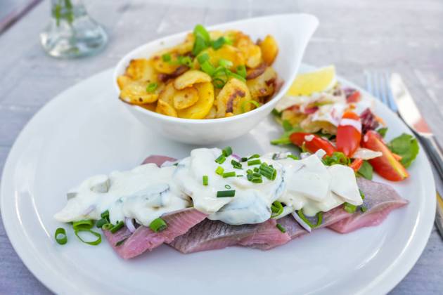 Matjes or soused herring, a mild salt fish with cream sauce containing onions, gherkins and apple, served with bratkartoffeln (German fried potatoes) and salad, selected focus Matjes or soused herring, a mild salt fish with cream sauce containing onions, gherkins and apple, served with bratkartoffeln (German fried potatoes) and salad, selected focus, narrow depth of field Copyright: xZoonar.com NarenxWinterx 19243454