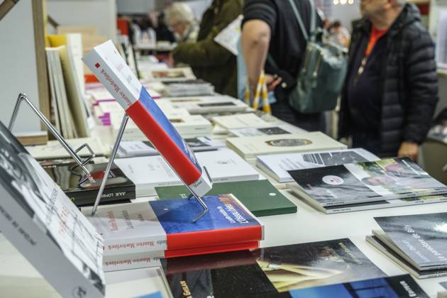 Foire du Livre de Bruxelles les gens se pressent autour des presentoirs 2023 Feuilleter un livre Brussels Books fair 2023 - Flipping the pages Reporters QUINET JEANxMARCxQUINET