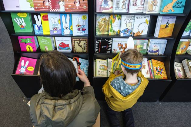 Foire du Livre de Bruxelles les gens se pressent autour des presentoirs 2023 Choisir un livre maman et enfant Brussels Books fair 2023 - Picking a book child and mother Reporters QUINET JEANxMARCxQUINET