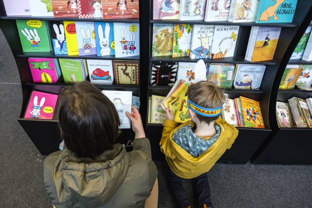 Foire du Livre de Bruxelles les gens se pressent autour des presentoirs 2023 Choisir un livre maman et enfant Brussels Books fair 2023 - Picking a book child and mother Reporters QUINET JEANxMARCxQUINET