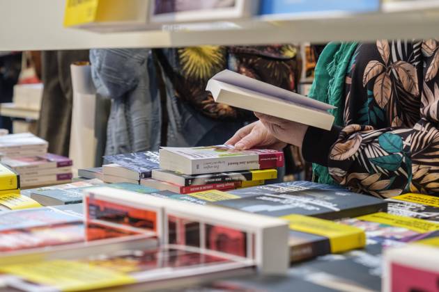 Foire du Livre de Bruxelles les gens se pressent autour des presentoirs 2023 Feuilleter un livre Brussels Books fair 2023 - Flipping the pages Reporters QUINET JEANxMARCxQUINET