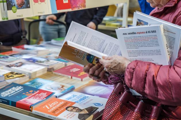 Foire du Livre de Bruxelles les gens se pressent autour des presentoirs 2023 Feuilleter un livre Brussels Books fair 2023 - Flipping the pages Reporters QUINET JEANxMARCxQUINET