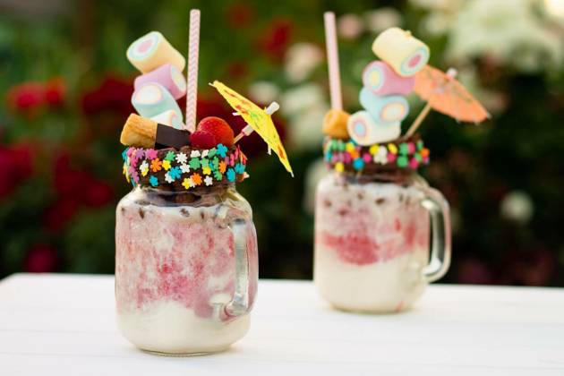 Freakshakes in jars with straw, marshmallow, strawberry, chocolate on a white table on a background of flowers., Freakshakes in jars with cocktail umbrella, straw, marshmallow, strawberry, chocolate on a white table on a background of summer flowers., Freakshakes in jars with cocktail umbrella, straw, marshmallow, strawberry, chocolate on a white table on a background of summer flowers., 26.03.2023, Copyright: xJeanniex Panthermedia33979390.jpg