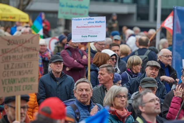 Der traditionelle Berliner Ostermarsch (Foto vom 08.04.2023) steht in diesem Jahr unter dem Motto Den Frieden gewinnen - nicht den Krieg . Die Veranstalter warnten unter anderem vor einer Eskalation des Krieges in der Ukraine. Deutschland mache sich durch Waffenlieferungen, permanente Kriegsrhetorik und durch Schueren von Feindbildern mitschuldig. Zeitgleich gab es auch eine alternative Veranstaltung unter dem Motto Kritische Einordnung des Berliner Ostermarsches . Bereits im vergangenen Jahr hatte es in Berlin zwei verschiedene Ostermaersche am selben Tag gegeben. Hintergrund ist ein unterschiedlicher Blick auf den Ukraine-Krieg. Im Bild: Ein Teilnehmer haelt ein Schild mit der Quedenkerparole Frieden schaffen ohne Waffen - Rechtstaat Copyright: epd-bild ChristianxDitsch D23D0408OstermarschBerlin130604