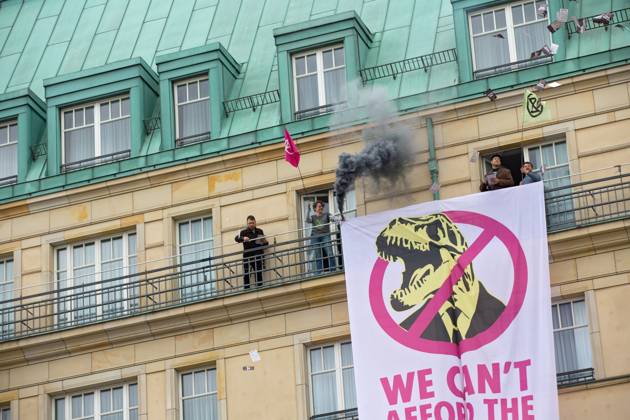 Berlin, Germany, DEU Extinction Rebellion, climate activists hijack Hotel Adlon 13.04.23, Berlin, Germany, DEU Extinction Rebellion, climate activists hijack Hotel Adlon Demonstrators add smoke candles and unfurl a banner on the balcony of one of the upper floors that reads We can™t afford the super rich Berlin Berlin Germany