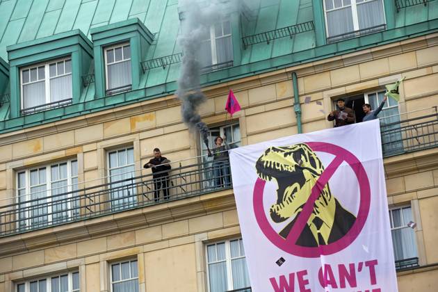 Berlin, Germany, DEU Extinction Rebellion, climate activists hijack Hotel Adlon 13.04.23, Berlin, Germany, DEU Extinction Rebellion, climate activists hijack Hotel Adlon Demonstrators add smoke candles and unfurl a banner on the balcony of one of the upper floors that reads We can™t afford the super rich Berlin Berlin Germany