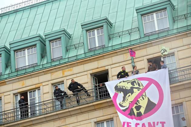 Berlin, Germany, DEU Extinction Rebellion, climate activists hijack Hotel Adlon 13.04.23, Berlin, Germany, DEU Extinction Rebellion, climate activists hijack Hotel Adlon Protesters add smoke candles and unfurl a banner on the balcony of one of the upper floors that reads We can™t afford the super rich Police officer