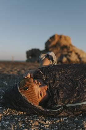 Woman wearing knit hat in sleeping bag at beach model released, Symbolfoto, DMGF01116