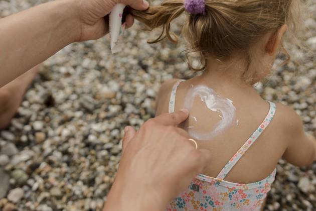 IMAGO Creative, Jahreszeit Sommer, Sonnenschutz Man drawing heart shape with suntan lotion on daughter model released, Symbolfoto, VIVF00523