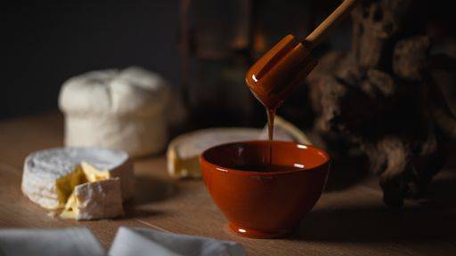 RECORD DATE NOT STATED A closeup of honey in a bowl and sliced camembert cheese on the table in the kitchen *** einer closeupe des Honig ÊIn einer Schüssel und aufgeschnittenen camembert Käse am der Tisch ÊIn der Küche 2660784