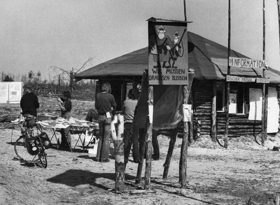 16.05.1980: Vor dem Infohaus im Hüttendorf, welches Atomkraftgegner auf dem von ihnen zur Freien Republik Wendland erklärten Gelände in Gorleben am geplanten Bohrloch 1004 errichtet haben, versorgen sich Interessierte mit Informationen. Ein Schild im Vordergund, auf dem zwei Polizisten als Karikaturen abgebildet sind, gibt zu verstehen: Wir müssen draussen bleiben . Die Errichtung des Hüttendorfes ist Ausdruck der starken Proteste gegen das hier zwecks Eignungsprüfung für die Lagerung von Atommüll geplante Erkundungsbergwerk, welches durch Probebohrungen am Salzstock Gorleben - Rambow vorbereitet werden soll. Maßgebliche Initiatoren die Copyright: ZINGLER,xFriedhelm docnrwhugopicture47884306 EDITORIAL USE ONLY