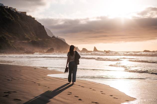 Young woman walking at a black sand beach at sunset Benijo, Canarias, Spain CR_NSRZ230515C5-1189284-01 ,model released, Symbolfoto