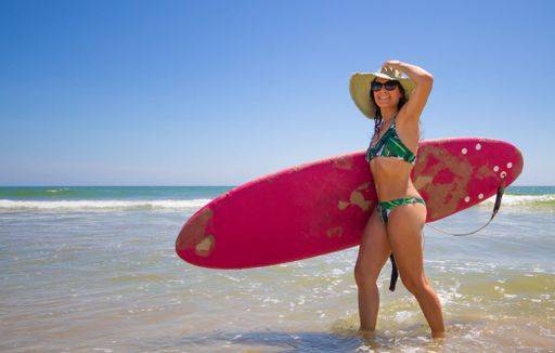 RECORD DATE NOT STATED A Hispanic woman wearing a swim wear while holding a surf board on the beach *** einer hispanisch Frau wearing einer Schwimm tragens wärend haltend einer Brandung Brett am der Strand 6936222 ,model released, Symbolfoto