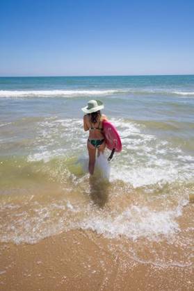 RECORD DATE NOT STATED A Hispanic woman wearing swimwear while holding a surfboard on the beach *** einer hispanisch Frau wearing Badekleidung wärend haltend einer Surfbrett am der Strand 6936254 ,model released, Symbolfoto
